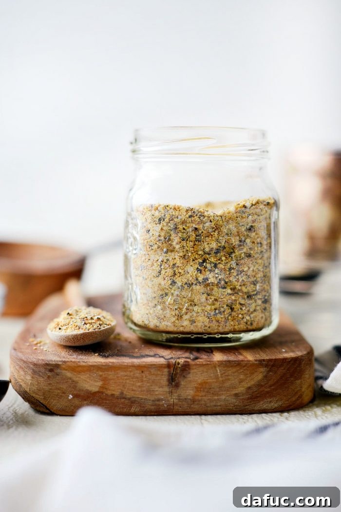 Close-up of the vibrant yellow and black specks of Homemade Lemon Pepper Seasoning in a small bowl.