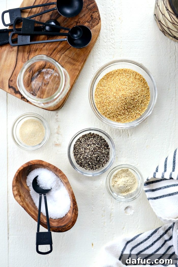 Ingredients for Homemade Lemon Pepper Seasoning laid out: dried lemon peel, black peppercorns, salt, onion powder, and garlic powder.