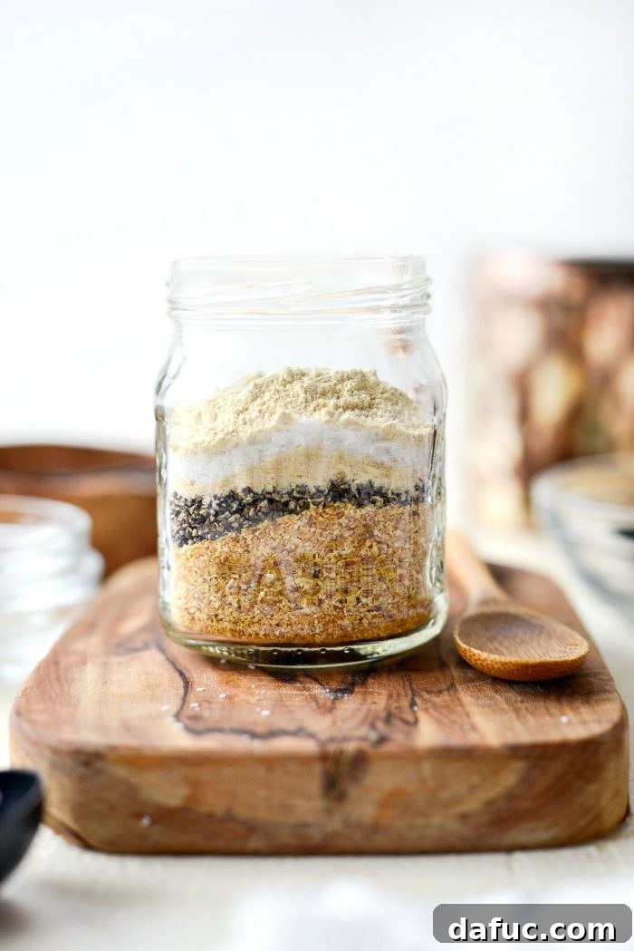 The combined ingredients for Homemade Lemon Pepper Seasoning in a glass bowl, showing a mix of yellow, black, and white specks.