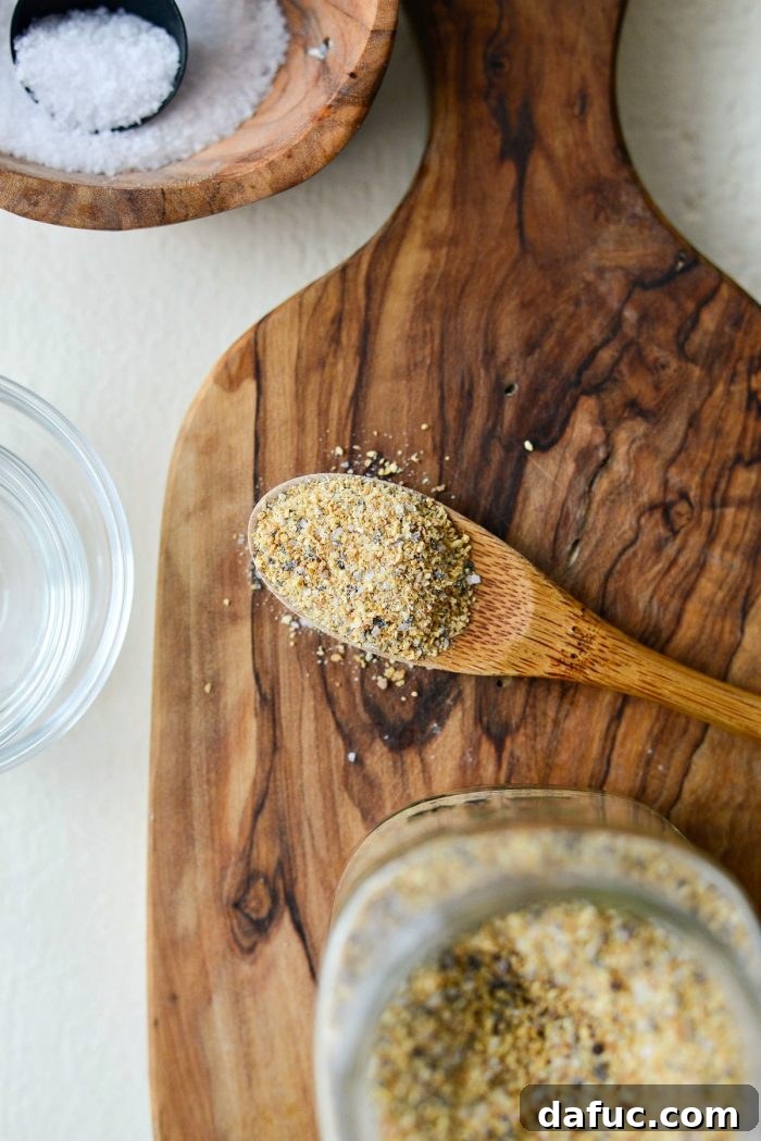 A small jar of Homemade Lemon Pepper Seasoning, labeled, on a rustic wooden surface, ready for storage or use.