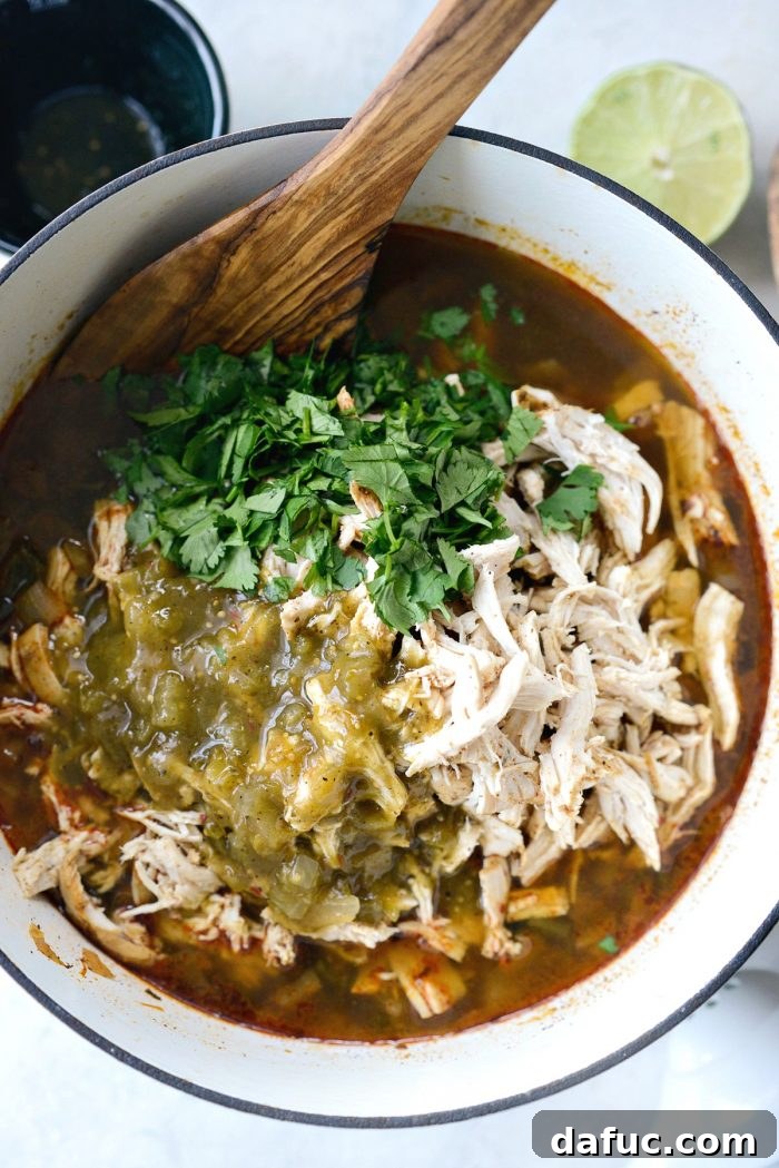 Hearty Poblano Chicken and White Bean Stew 15 Cooked chicken breasts resting on a cutting board, ready for shredding