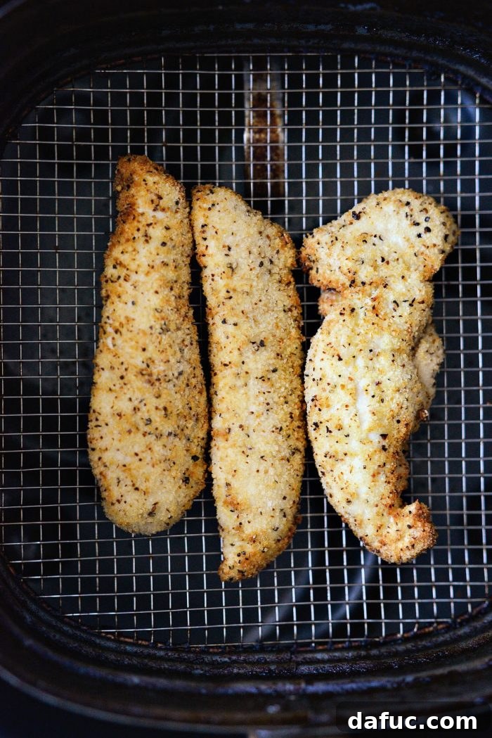 Air Fryer Lemon Pepper Chicken Tenders cooking in the air fryer