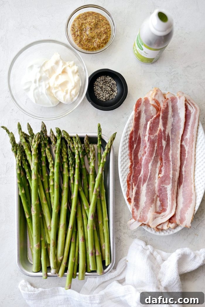 Crispy Bacon Asparagus Treats 4 Ingredients for Bacon Wrapped Asparagus Bundles laid out on a table