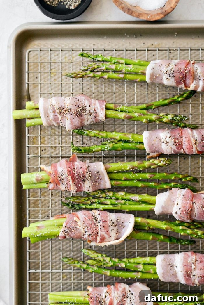 Crispy Bacon Asparagus Treats 9 Arranging the wrapped asparagus bundles on a wire rack on a baking sheet