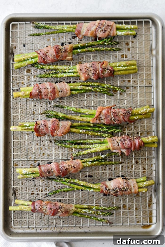 Crispy Bacon Asparagus Treats 10 Roasted bacon wrapped asparagus bundles on a wire rack