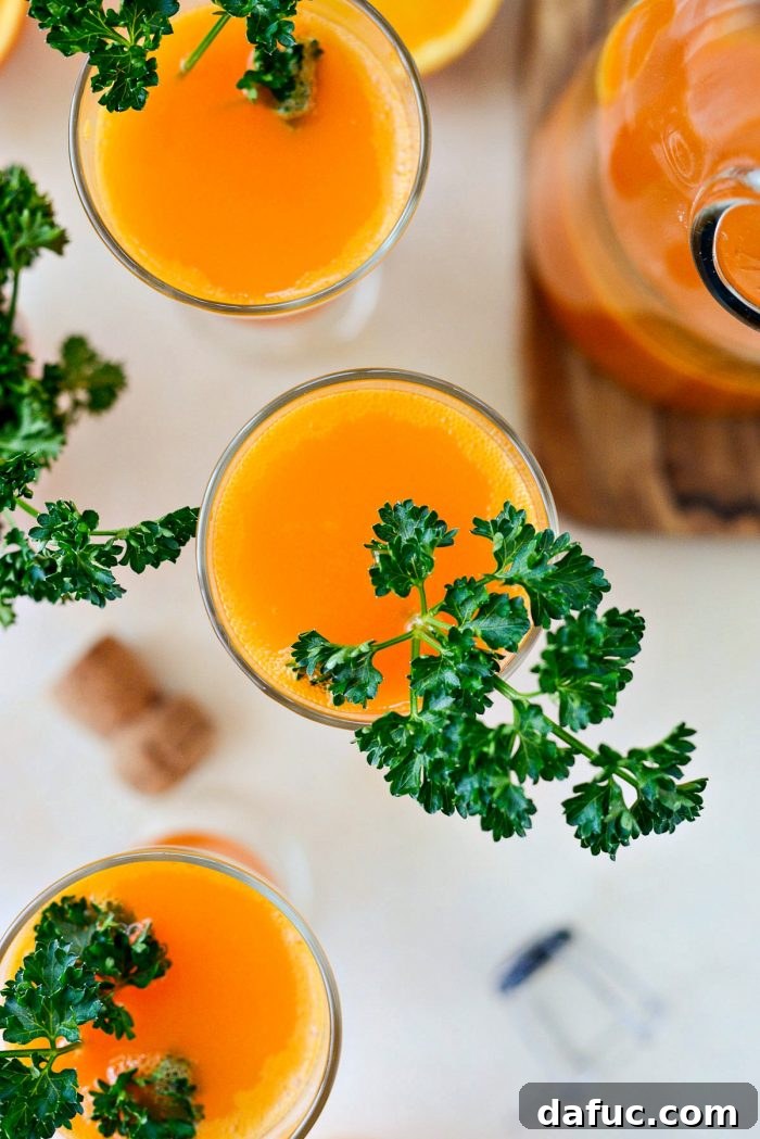 Golden Glow Mimosa 11 A Carrot Orange Mimosa garnished with a fresh sprig of curly leaf parsley, playfully resembling carrot tops, in a elegant flute.