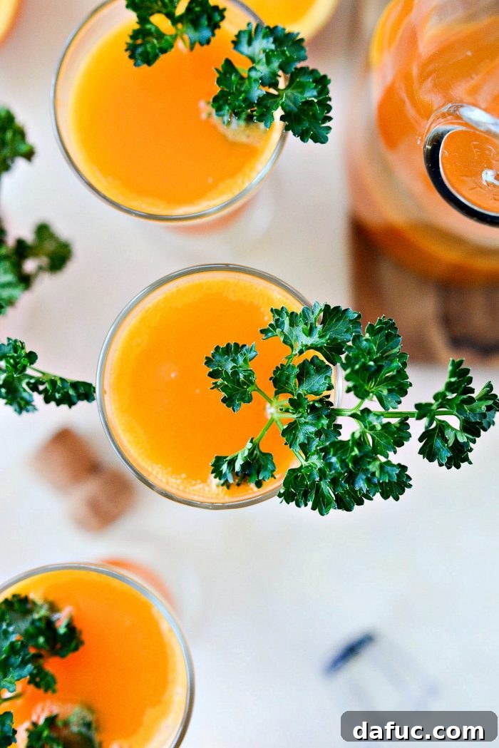 Golden Glow Mimosa 13 A single Carrot Orange Mimosa, perfectly garnished with parsley, placed on a light wooden surface, ready to be enjoyed.