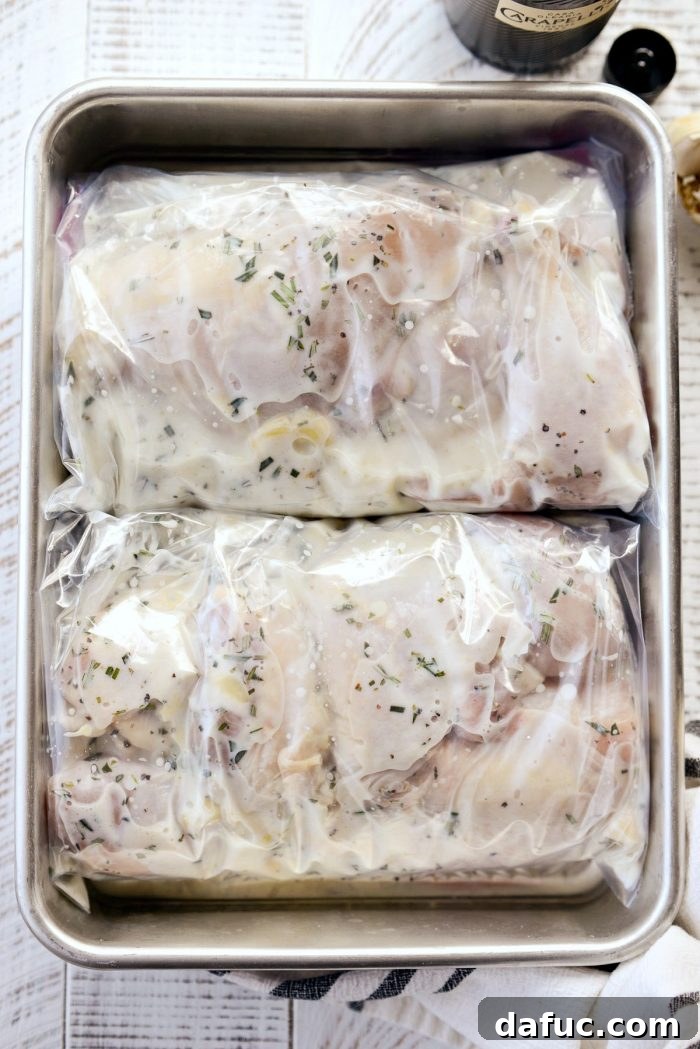 Sealed bags of buttermilk-marinated chicken, placed flat in a pan for refrigeration.