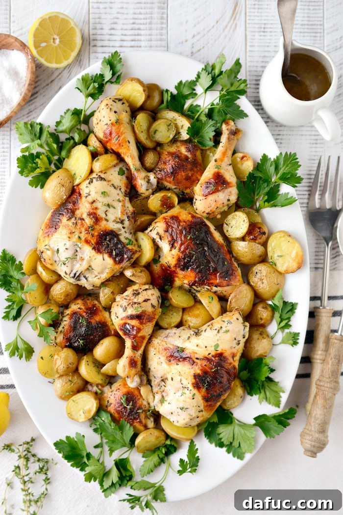 Platter of Buttermilk Roasted Chicken and potatoes, garnished and ready to serve, with a lemon wedge.
