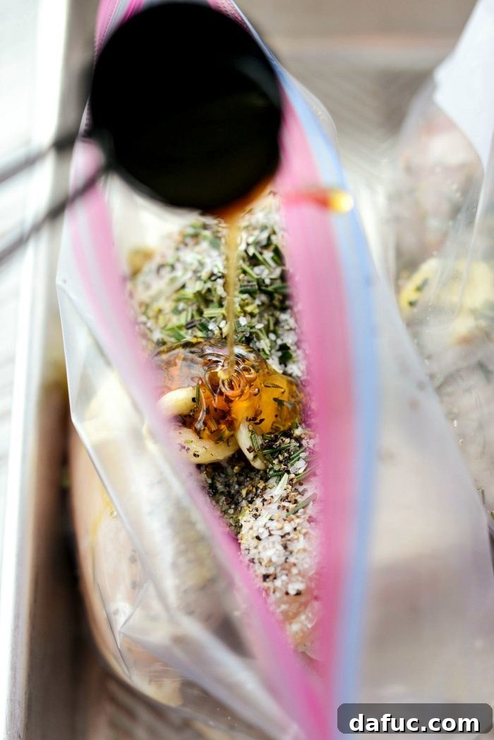 Olive oil being poured into a bag of chicken for the marinade.