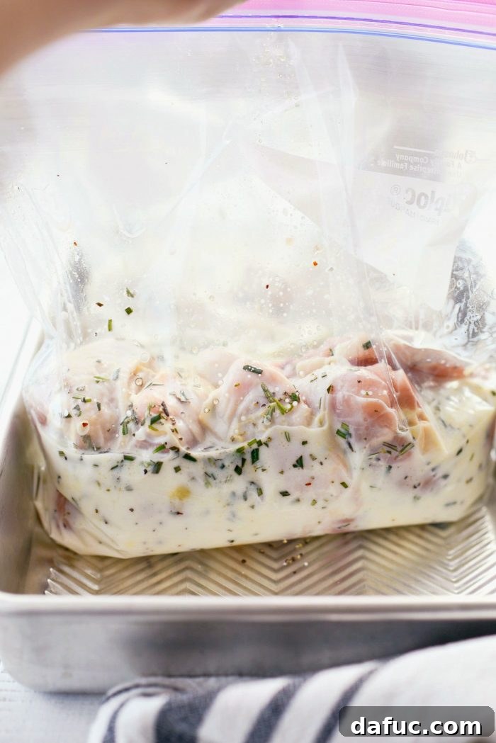 Buttermilk being poured into a bag of chicken and marinade ingredients.