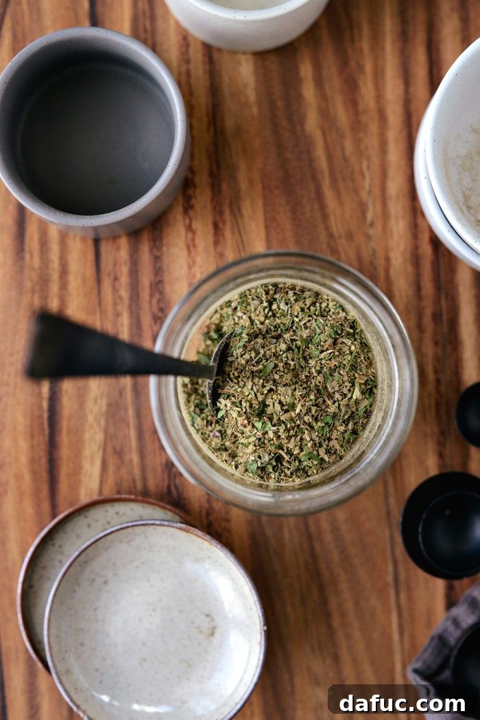 A close-up shot of the finished Homemade Italian Seasoning Blend in a small, elegant glass jar, sealed and ready for the pantry.
