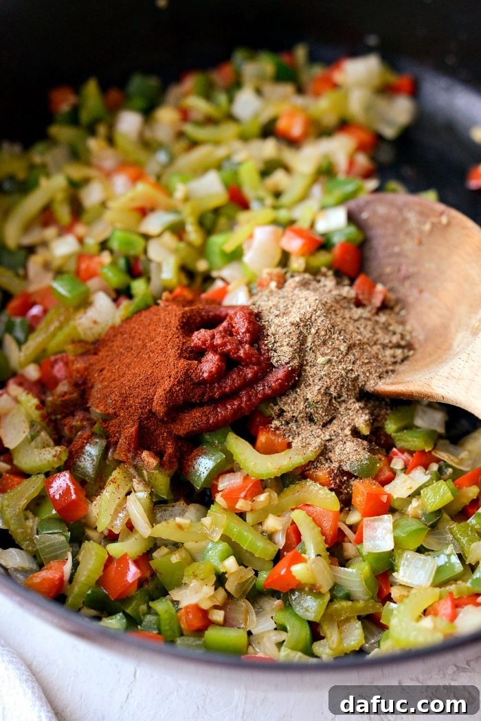 Effortless One-Pot Jambalaya 12 Tomato paste, Cajun seasoning, and smoked paprika added to the softened vegetables in the skillet, ready to be stirred in.