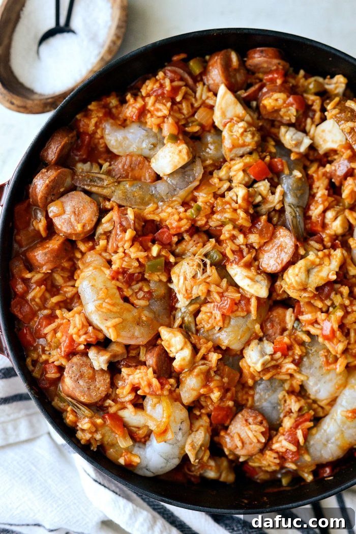 Effortless One Pot Jambalaya 21 Gently stirring shrimp, chicken, and sausage into the One Pot Jambalaya | SimplyScratch.com #skillet #shrimp #andouille #rice #creole #chicken #homemade