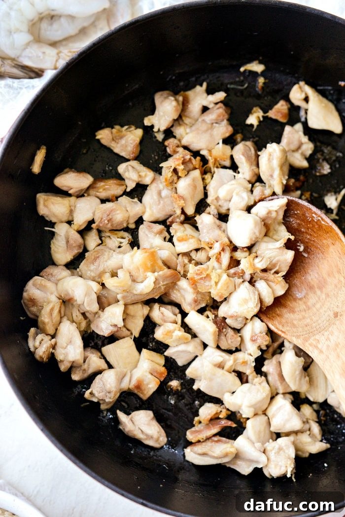 Effortless One Pot Jambalaya 6 Diced chicken thighs browning in a skillet for Jambalaya | SimplyScratch.com #skillet #shrimp #andouille #rice #creole #chicken #homemade