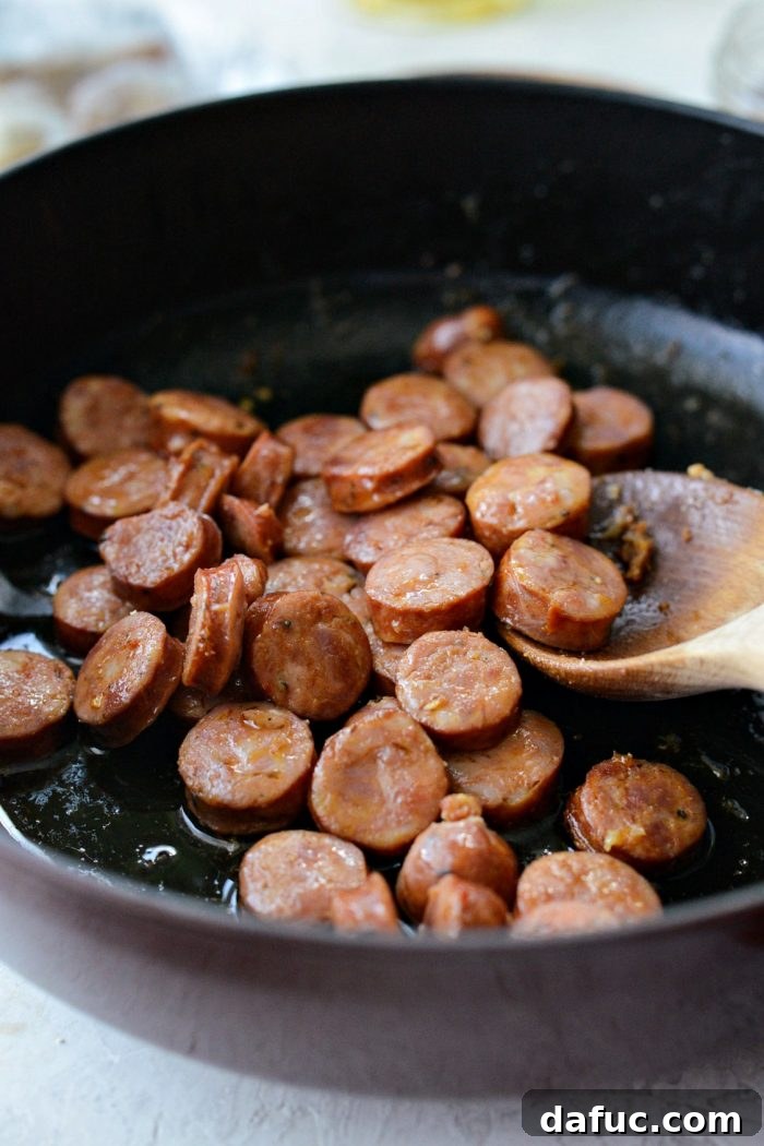 Effortless One-Pot Jambalaya 7 Sliced andouille sausage browning in the same skillet after the chicken, adding smoky flavor to the one-pot jambalaya.