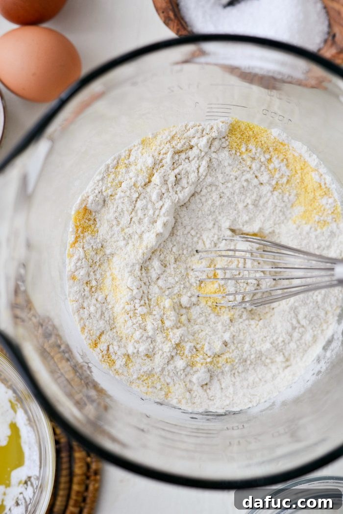 Classic Golden Cornbread 5 Mixing dry ingredients for cornbread in a large bowl.