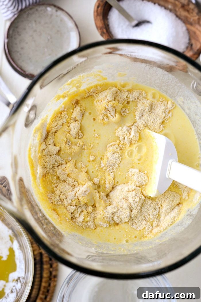 Classic Golden Cornbread 8 Wet ingredients being poured into dry cornbread mixture.
