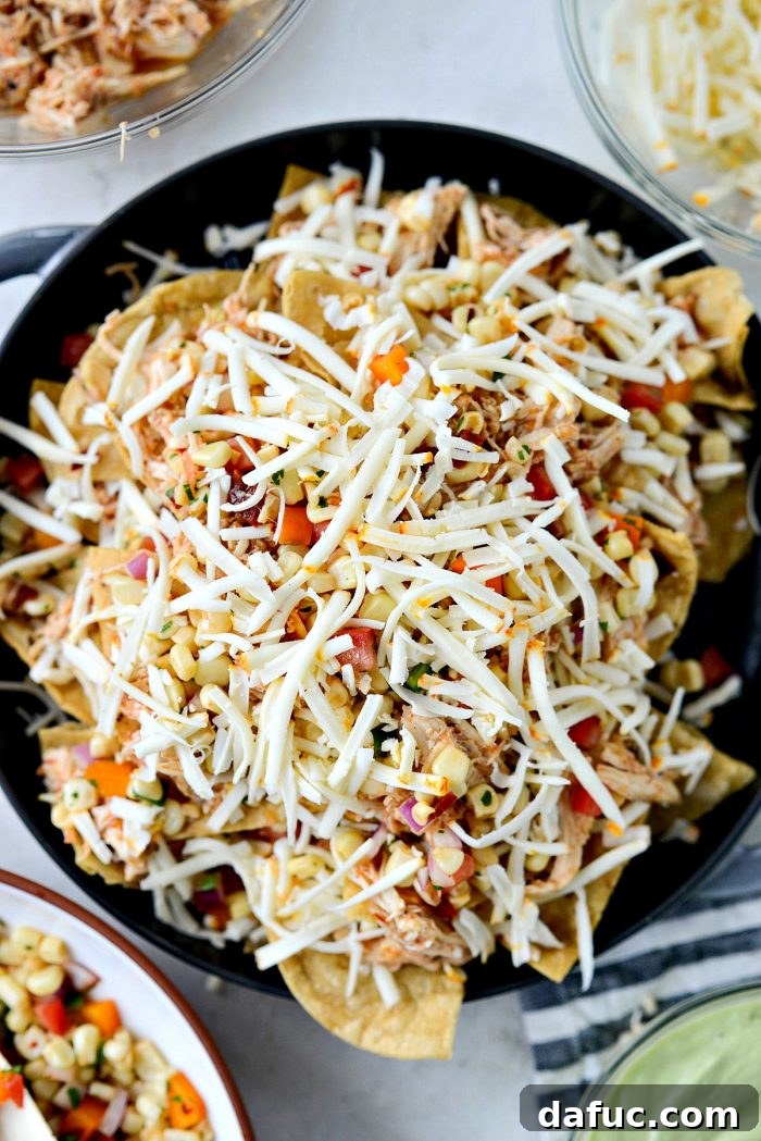 Golden Lava Chicken Nachos 8 Repeating the layering process for Jacuzzi Chicken Nachos: another layer of chips, chicken, cheese, and smoky corn salsa, building up the flavorful stack.