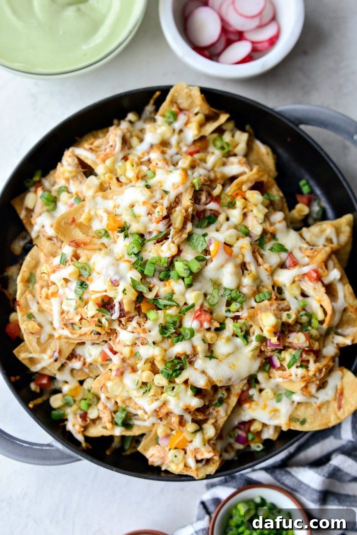 Golden Lava Chicken Nachos 9 The final layer of shredded Muenster cheese covers the Jacuzzi Chicken Nachos before baking, promising a golden, bubbly top.