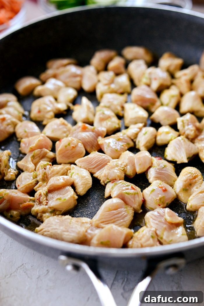 Zesty Ponzu Chicken Rice Bowls 9 Diced chicken added to a hot skillet with sesame oil, with the reserved marinade in a bowl nearby.