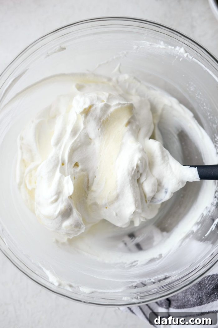 A bowl of light and fluffy whipped cream cheese mixture, perfectly blended and ready for layering.