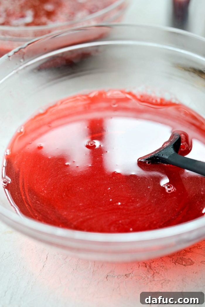 The Jell-O mixture being stirred vigorously until it is completely dissolved and transparent.