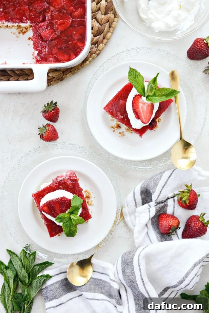 Slicing the chilled strawberry pretzel dessert bars into neat squares, revealing the beautiful layers.