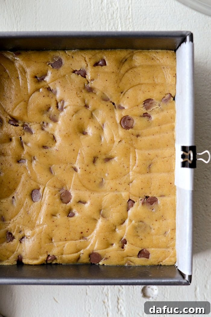 Golden Brown Butter Chocolate Chip Blondies 17 The baking pan with blondie batter being placed into the preheated oven.