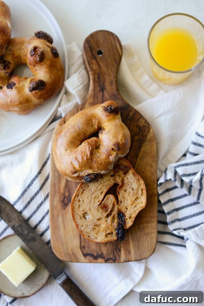 Homemade Air Fryer Cinnamon Raisin Bagels 2 sliced and toasted cinnamon raisin bagel on wood cutting board