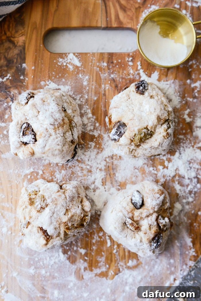 Homemade Air Fryer Cinnamon Raisin Bagels 17 fourths rolled in a little flour on wood cutting board.