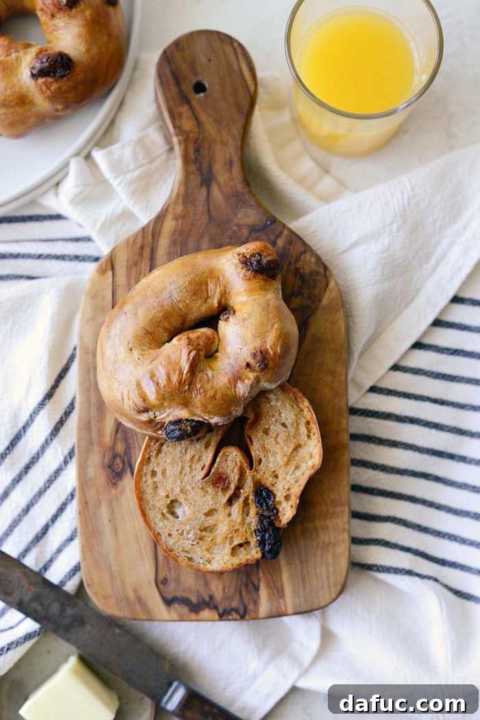 Homemade Air Fryer Cinnamon Raisin Bagels 30 air fryer cinnamon raisin bagel on wood cutting board for serving.