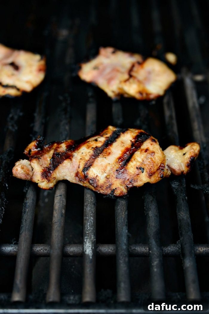 Vibrant Grilled Thai Chicken Salad 13 Grilled chicken thighs on a cutting board, cooked to a golden brown perfection.