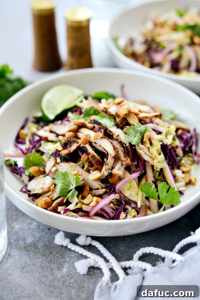 Vibrant Grilled Thai Chicken Salad 19 Side view of a large serving of Grilled Thai Chicken Salad, showing layers of chicken, cabbage, and other ingredients.