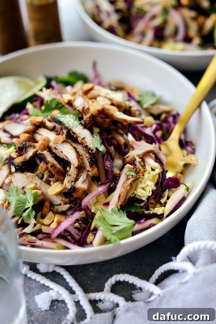 Vibrant Grilled Thai Chicken Salad 3 Close-up of a forkful of Grilled Thai Chicken Salad, showcasing the grilled chicken, fresh herbs, and vibrant cabbage.