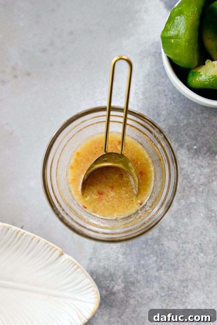Vibrant Grilled Thai Chicken Salad 9 A small bowl with reserved marinade, now with 2 teaspoons of light olive oil being whisked in to create the salad dressing.