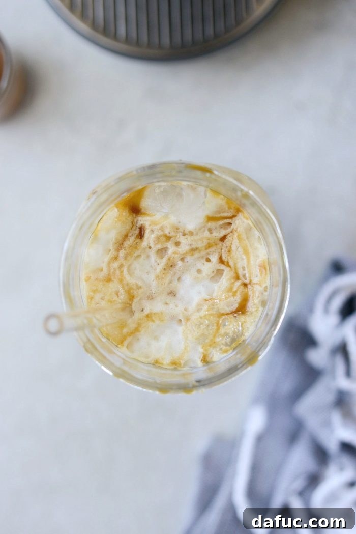 Velvet Caramel Vanilla Chill 15 Close-up of the top of an Iced Caramel Vanilla Latte, showing frothy milk and caramel.