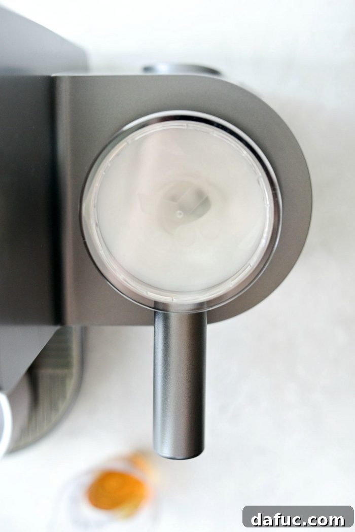 Velvet Caramel Vanilla Chill 6 Milk frothing in a frother machine, creating a thick foam.