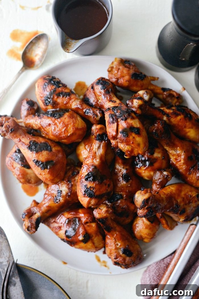 Sticky Sweet BBQ Drumsticks 2 Easy BBQ Chicken Drumsticks on a round platter, glistening with homemade sauce and ready to be served at a summer cookout.
