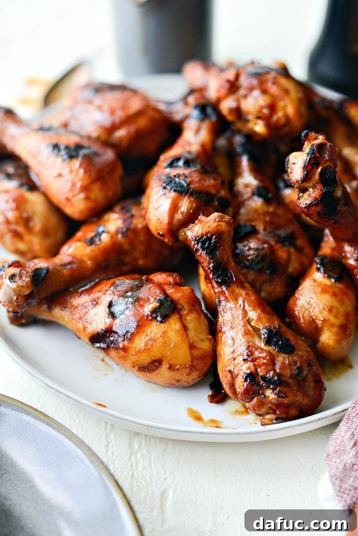 Sticky Sweet BBQ Drumsticks 3 A vibrant display of easy BBQ chicken drumsticks arranged on a pristine white platter on outdoor tables, inviting guests to a delightful summer meal.