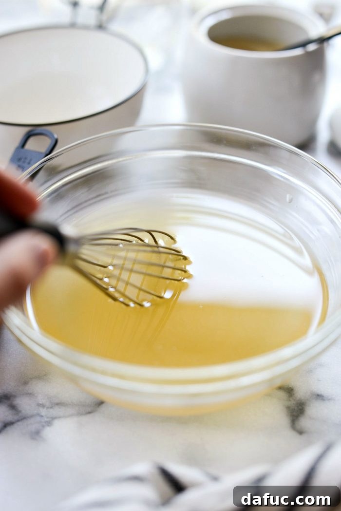 Zesty Quick Pickled Red Onions 6 Whisking apple cider vinegar and warm water in a bowl to dissolve sugar and salt