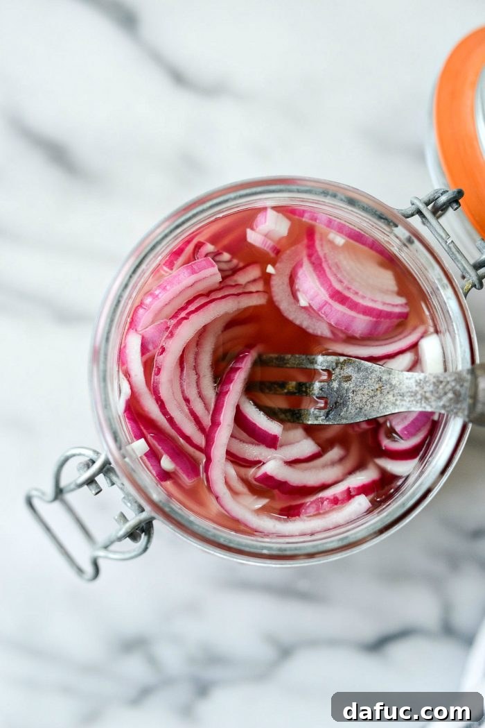 Zesty Quick Pickled Red Onions 10 Stirring quick pickled red onions in a glass jar to ensure even pickling