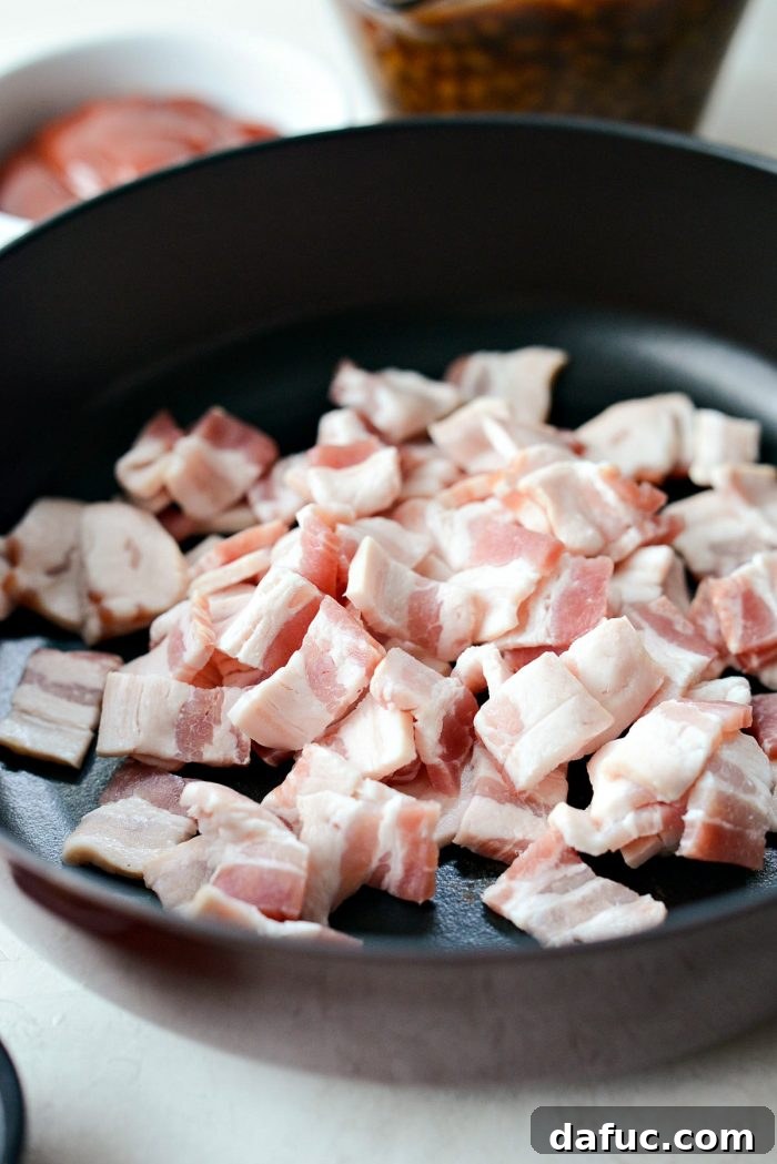 One Pot Wonder Baked Beans 5 close up of chopped bacon in a cold skillet, ready to be cooked