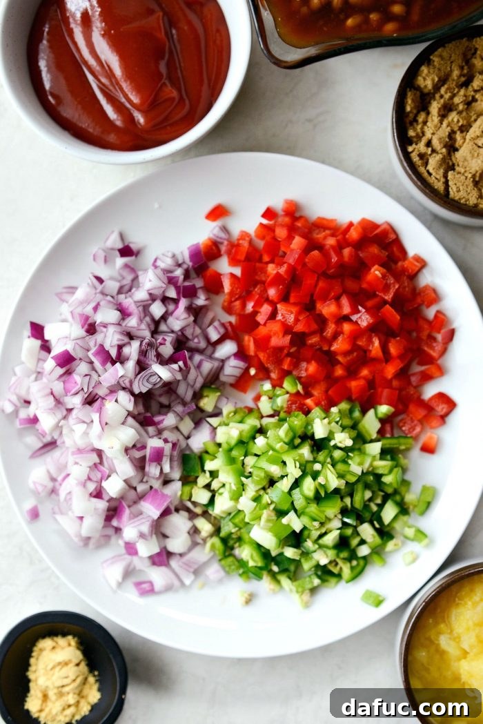 One Pot Wonder Baked Beans 7 a cutting board with neatly diced red onion, red bell pepper, and jalapeños