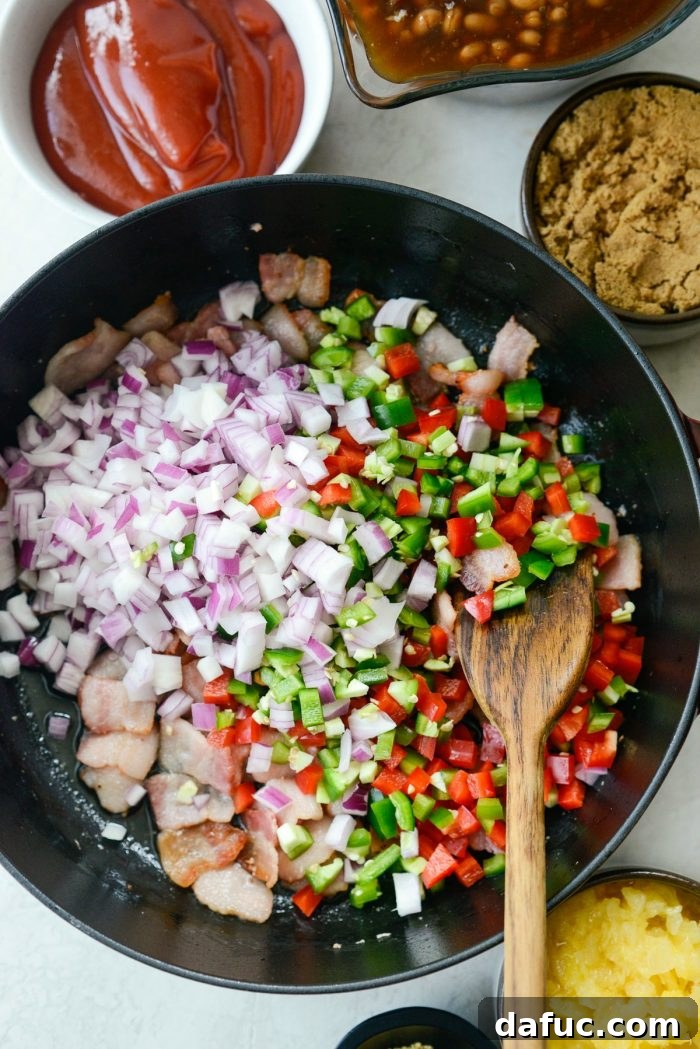 One Pot Wonder Baked Beans 8 diced onions, bell peppers, and jalapeños added to the skillet with bacon fat, beginning to soften