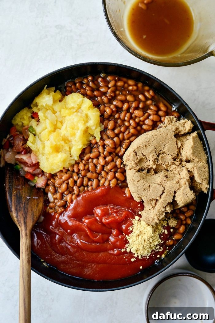One Pot Wonder Baked Beans 10 all ingredients, including beans, pineapple, brown sugar, ketchup, and sauces, added to the pot with vegetables and bacon