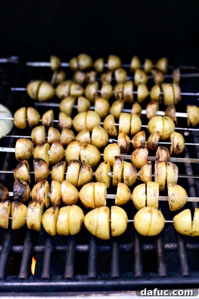 Grilled potatoes on metal skewers, perfectly cooked and lightly charred.