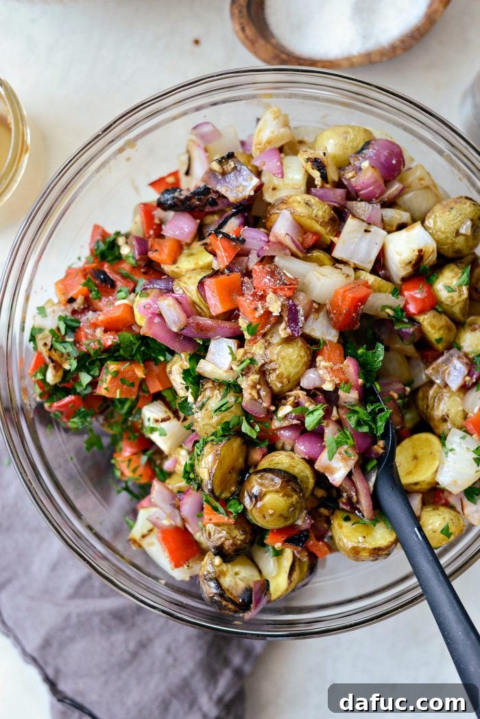 Tossed potato salad ingredients in a bowl, perfectly coated with dressing.