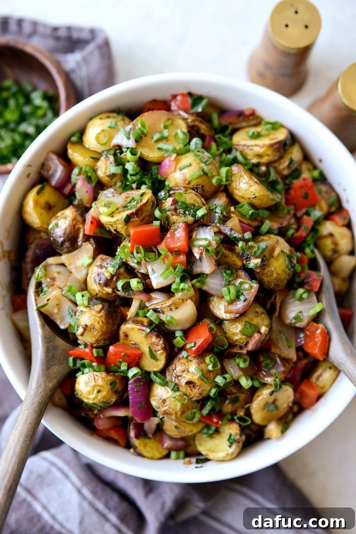 Tuck's potato salad in a cream bowl with elegant grey wood serving spoons.