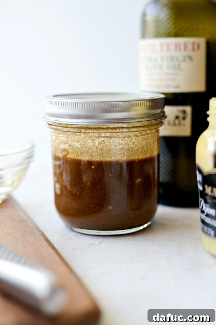 Shaking the dressing vigorously to combine all ingredients.
